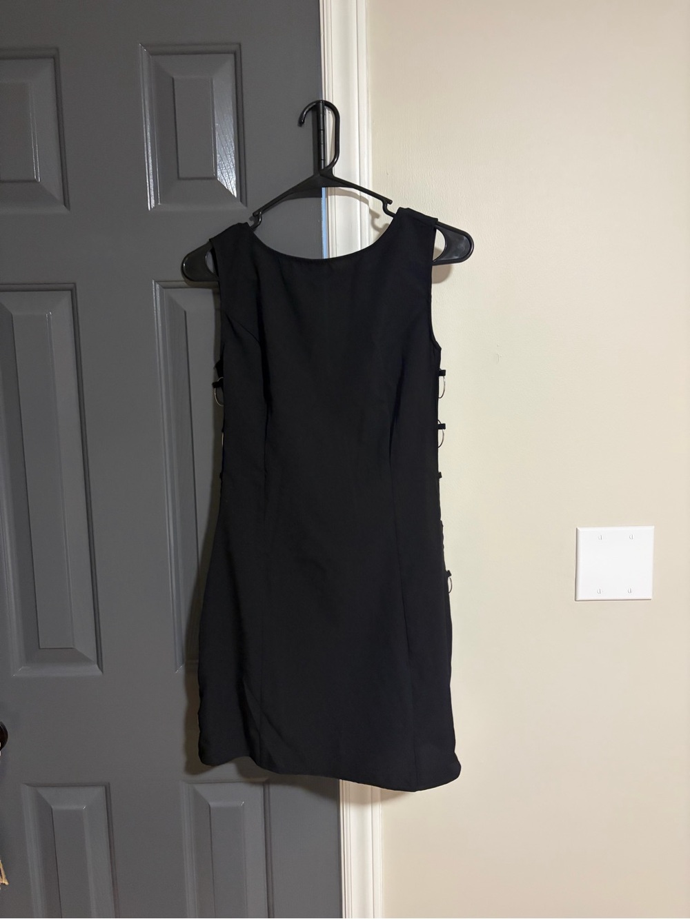 Sleek Black Sleeveless Mini Dress with Side Buckle Accents